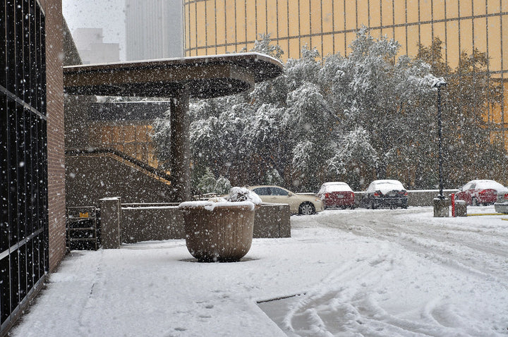 A snowy day next to a corporate building.