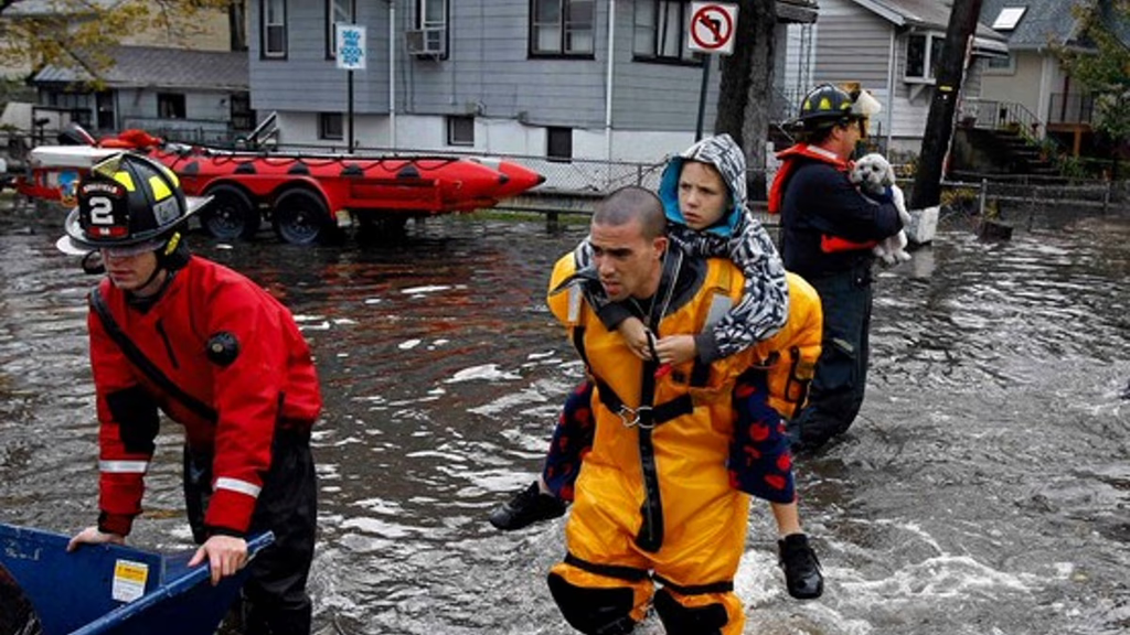 Rescue workers saving a child and dog during a flood.