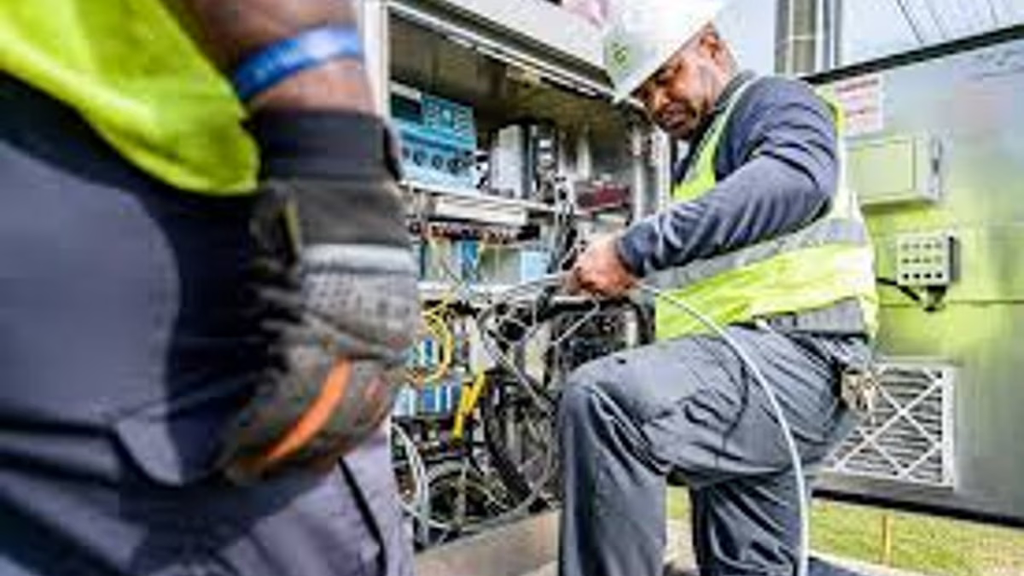 An electrician propping his knee up while he works on electrical wires.