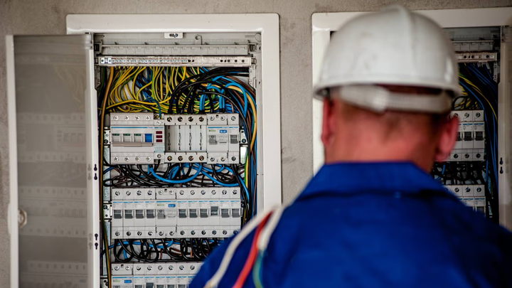 An electrician looking at a plethora of electrical wires.