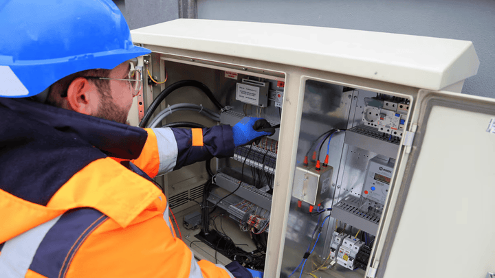 An electrician using a knob inside an electrical box.