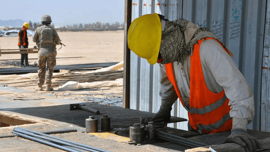 A construction worker looking at different types of building screws.