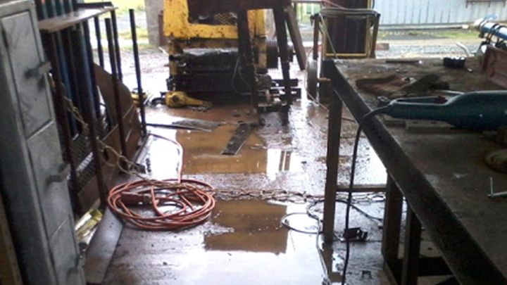 A wet work environment with puddles of water on the ground.