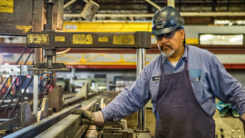 A factory worker leading a conveyer belt.