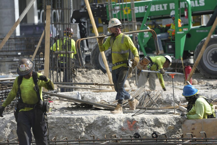 Construction workers carrying beams.